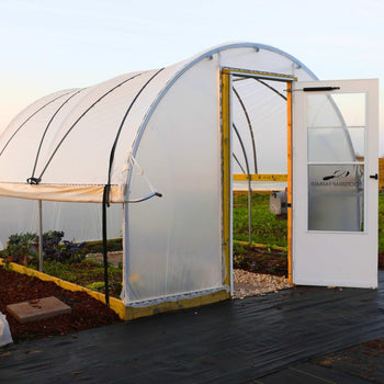 A hoop house greenhouse built from a kit.
