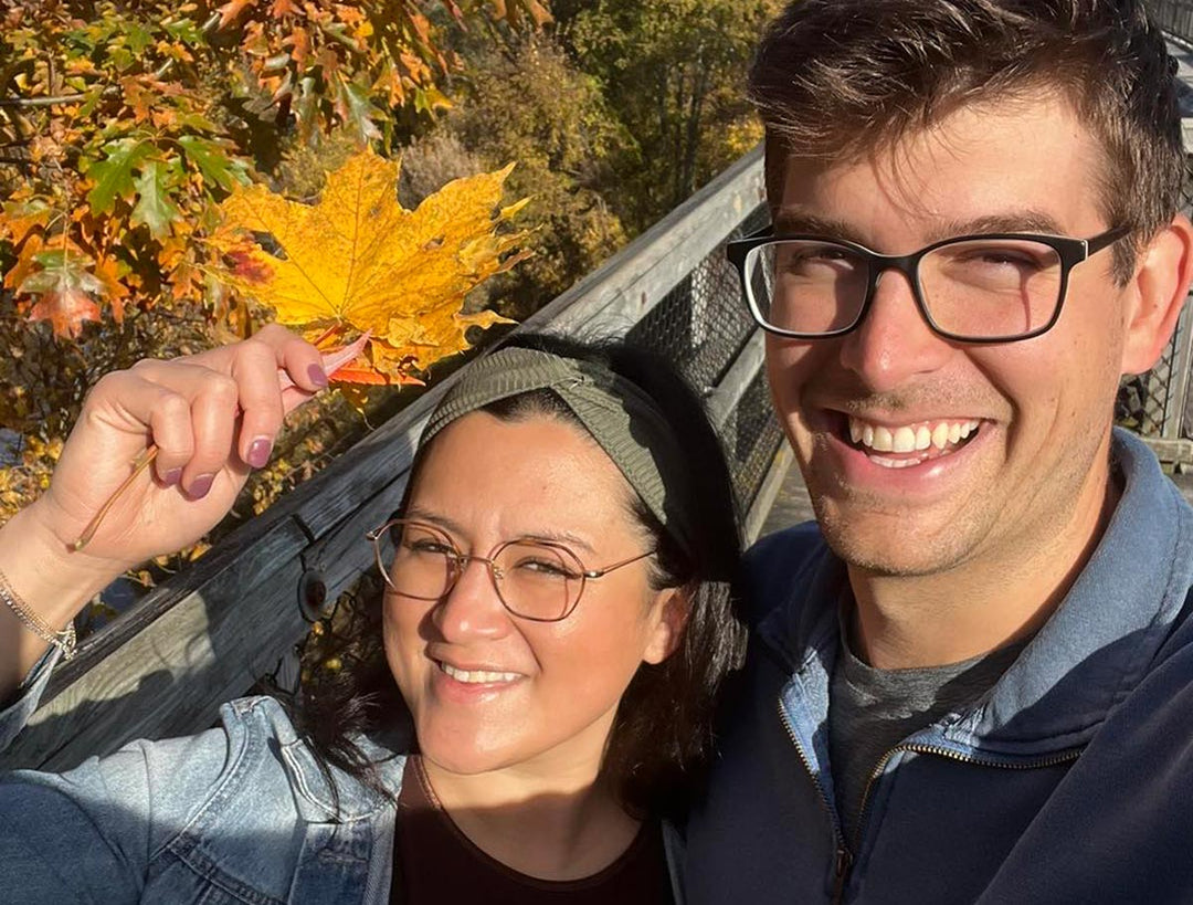 A couple walking in the fall foliage.