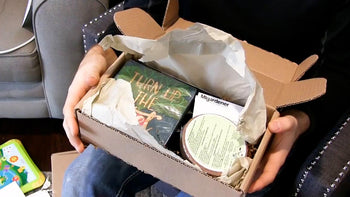 A man opening a gift full of gardening items.