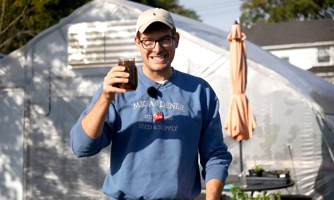 A man holding homemade seaweed fertilizer.