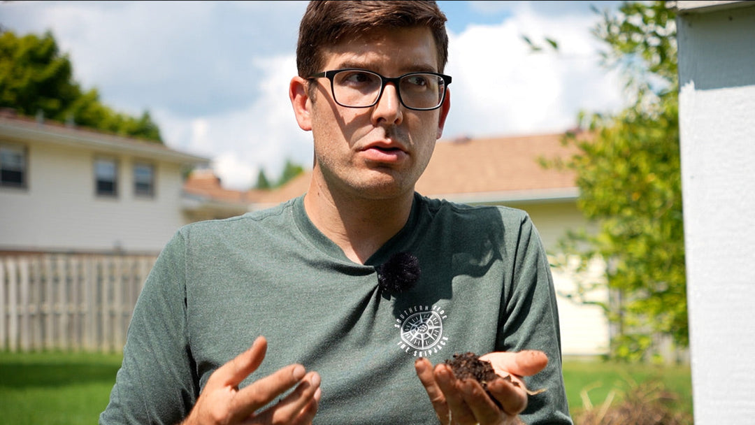 A man holding a handful of soil, looking for soil mites.